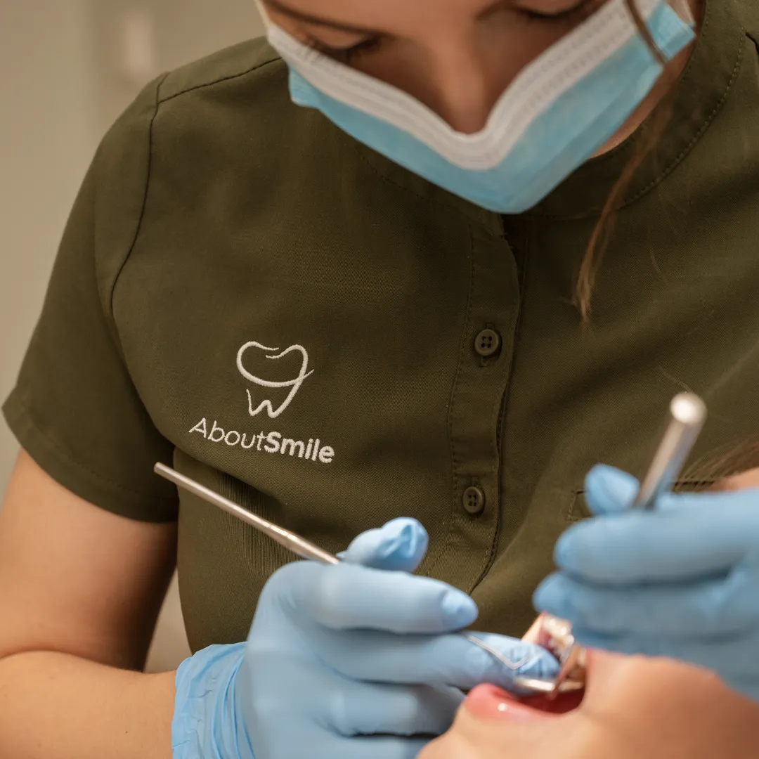 About Smile gydytoja apžiūri pacientės dantis konsultacijos metu